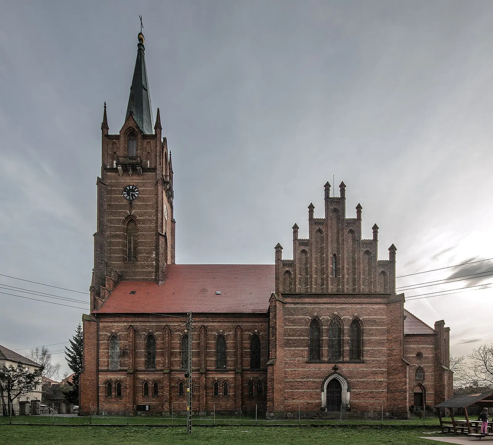 Neogotycki ceglany kościół św. Stanisława Kostki w Żmigrodzie z wysoką wieżą